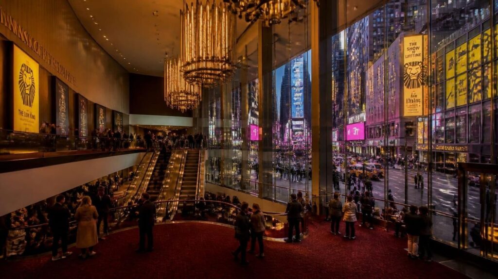 Cinematic eye-level shot of the covered pedestrian breezeway entrance to the Minskoff Theatre on West 45th Street in Times Square